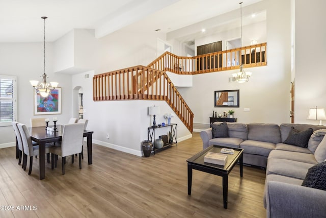 living room featuring a notable chandelier, beam ceiling, and wood-type flooring