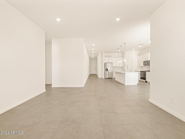 unfurnished living room with sink and light tile patterned floors