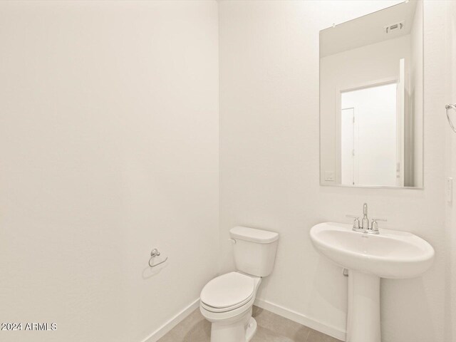 bathroom with toilet and tile patterned flooring