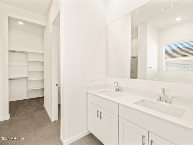 bathroom featuring toilet, vanity, and tile patterned flooring