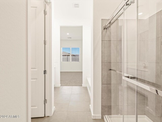 bathroom featuring walk in shower and tile patterned flooring