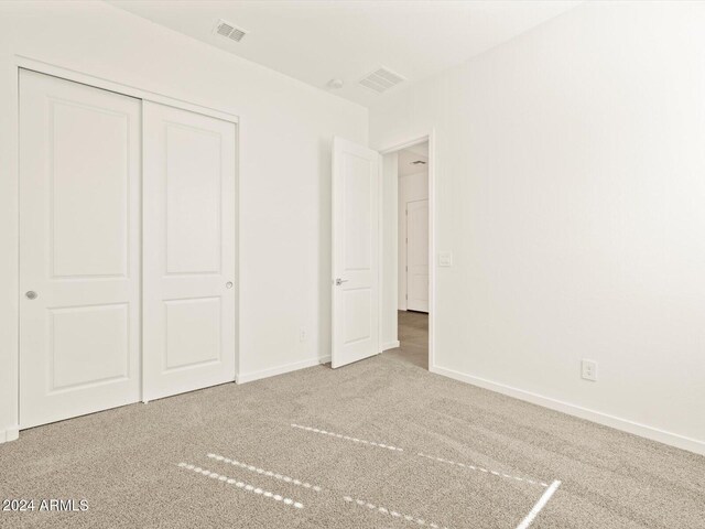 unfurnished bedroom with a closet and carpet floors