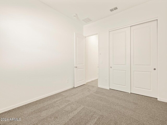 unfurnished bedroom with a closet and carpet flooring