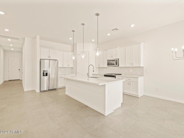 kitchen featuring white cabinets, sink, a kitchen island with sink, and appliances with stainless steel finishes