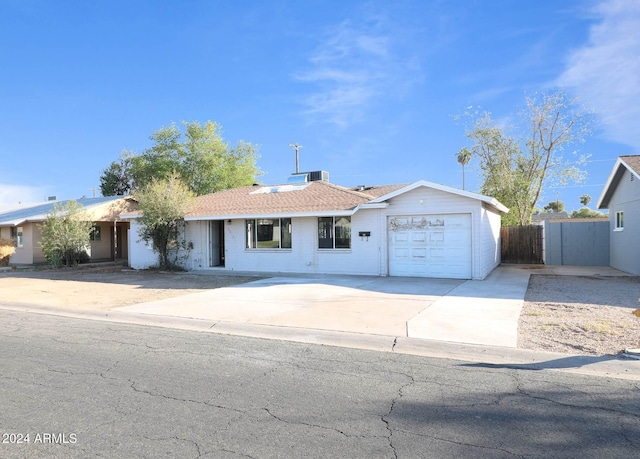 ranch-style home with a garage and cooling unit