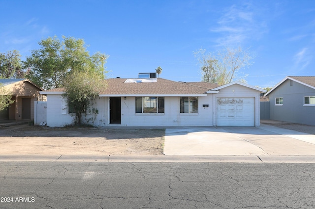 ranch-style home featuring cooling unit and a garage