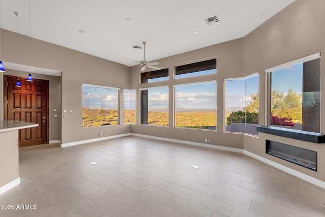 16814 N Boulder Dr, Fountain Hills, AZ 85268 - empty room with a ceiling fan, light tile patterned floors, baseboards, and a glass covered fireplace