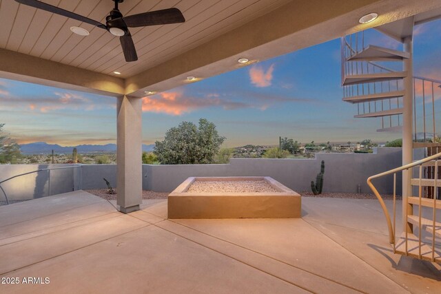 16814 N Boulder Dr, Fountain Hills, AZ 85268 - patio terrace at dusk with stairs, an outdoor fire pit, a fenced backyard, and a ceiling fan