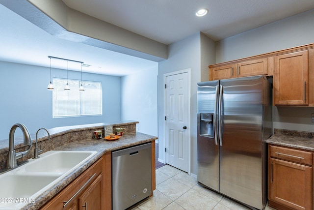 kitchen featuring decorative light fixtures, light tile patterned flooring, appliances with stainless steel finishes, and sink