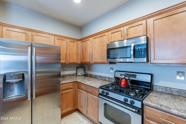 kitchen featuring light tile patterned floors and stainless steel appliances