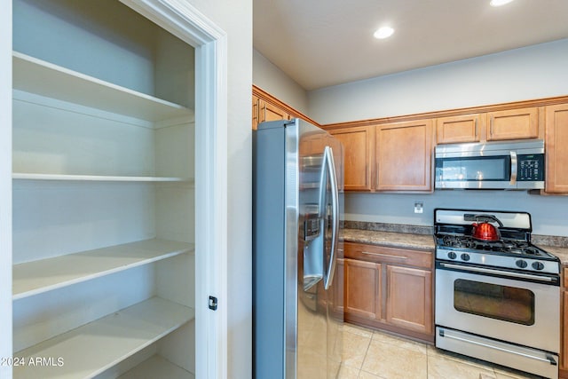 kitchen with light tile patterned flooring and stainless steel appliances