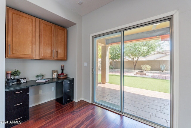 entryway with dark wood-type flooring and built in desk