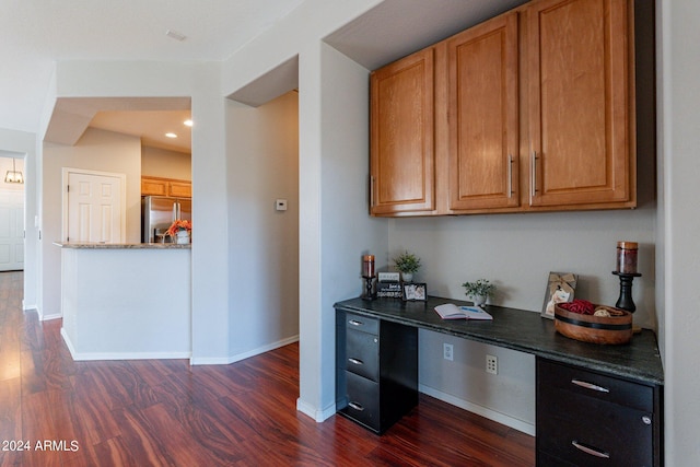 kitchen featuring built in desk, dark wood-type flooring, and stainless steel refrigerator with ice dispenser