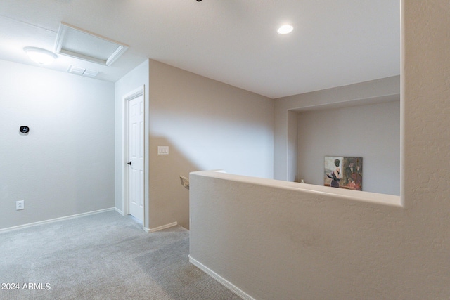 hallway featuring light colored carpet