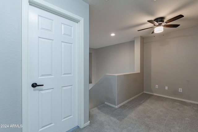 basement featuring light carpet and ceiling fan