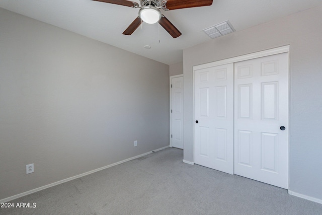 unfurnished bedroom featuring ceiling fan, a closet, and light carpet