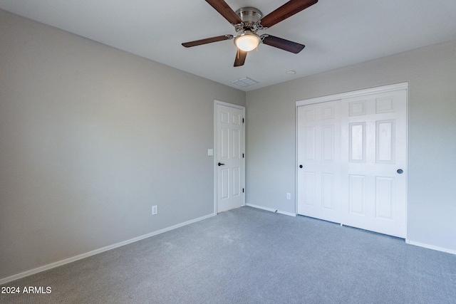 unfurnished bedroom with ceiling fan, a closet, and carpet