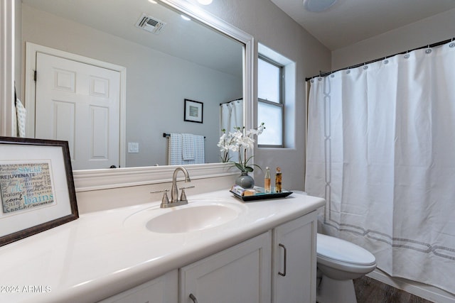 bathroom with walk in shower, hardwood / wood-style floors, vanity, and toilet