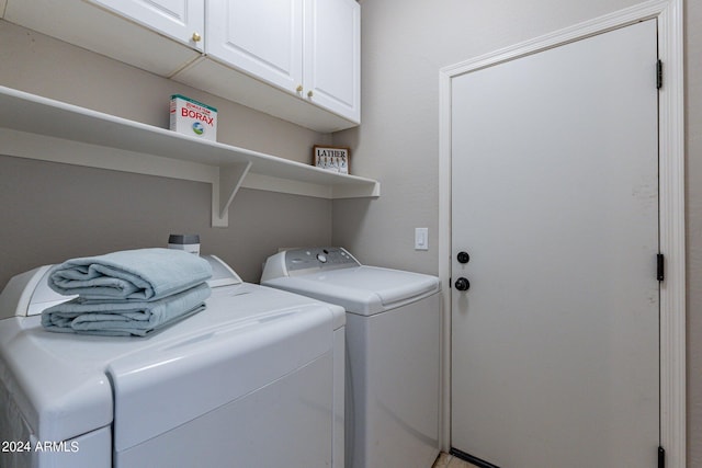 washroom with washer and dryer and cabinets