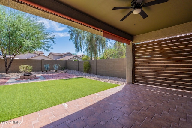 view of yard featuring an outdoor fire pit, ceiling fan, and a patio