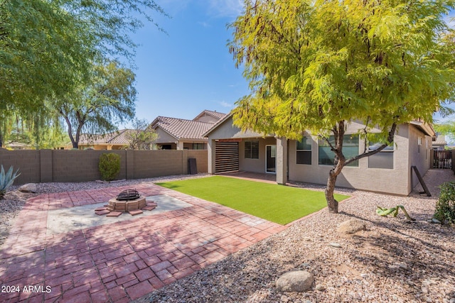 rear view of house featuring a patio and an outdoor fire pit