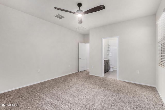 unfurnished bedroom featuring ensuite bath, light colored carpet, and ceiling fan