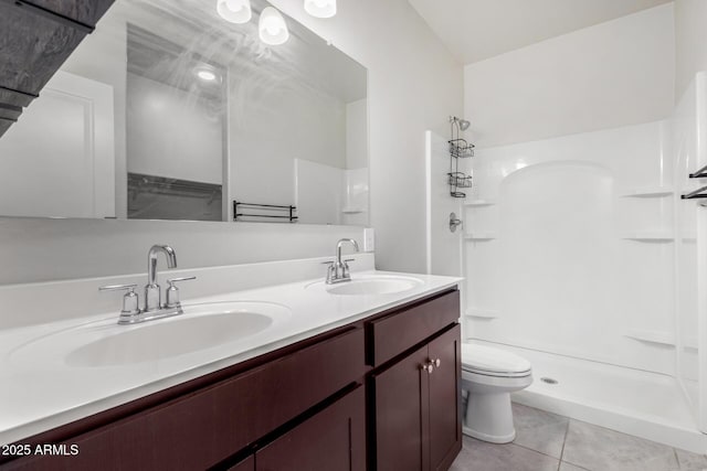 bathroom featuring toilet, tile patterned floors, walk in shower, and vanity