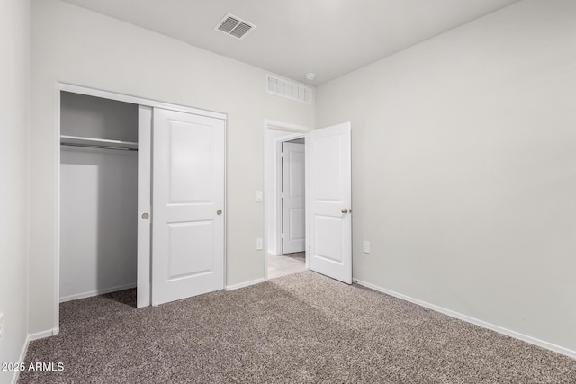 unfurnished bedroom featuring carpet flooring and a closet