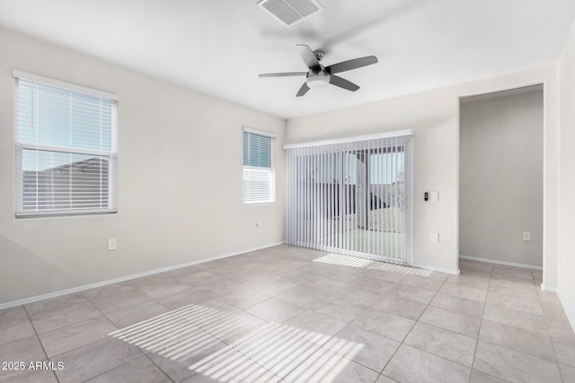 tiled empty room featuring ceiling fan and plenty of natural light