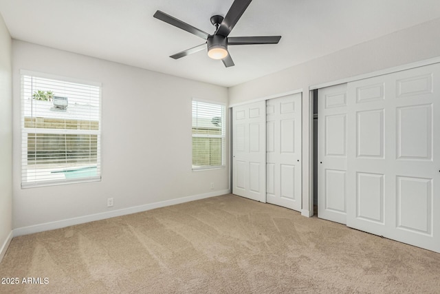 11021 N 55th Dr, Glendale, AZ 85304 - unfurnished bedroom with baseboards, multiple closets, light carpet, and ceiling fan
