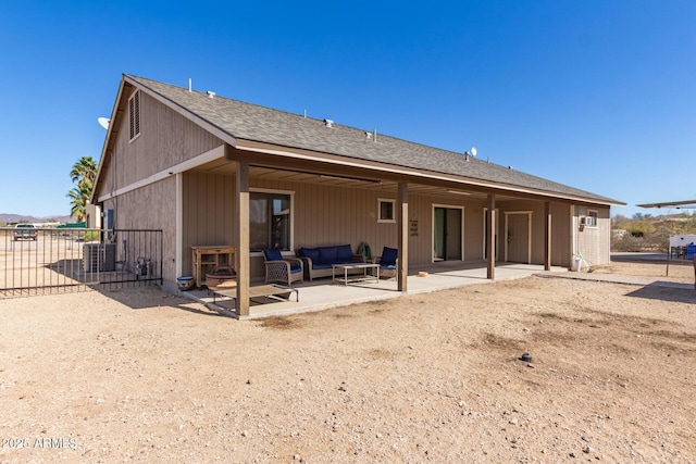 rear view of house with a patio area, fence, outdoor lounge area, and roof with shingles