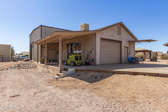 view of side of property with driveway, cooling unit, and a gazebo