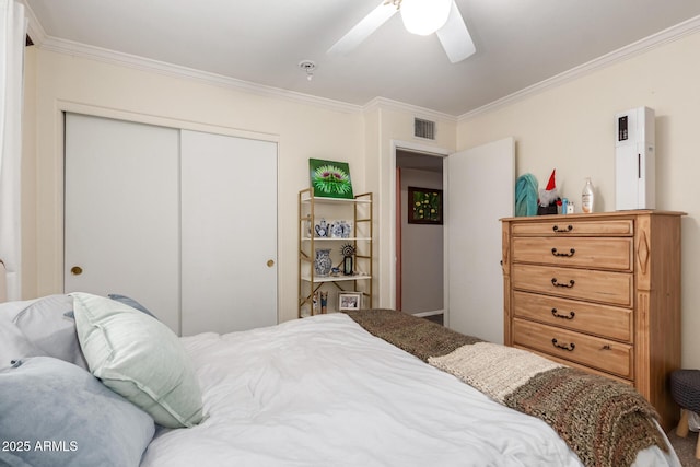 bedroom with a ceiling fan, crown molding, visible vents, and a closet