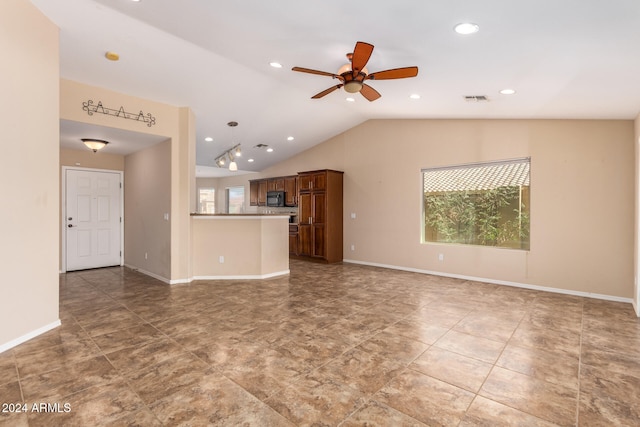 unfurnished living room with ceiling fan, plenty of natural light, and vaulted ceiling