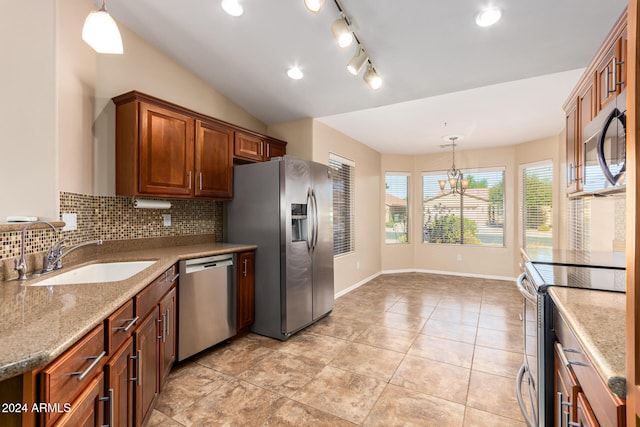 kitchen with hanging light fixtures, backsplash, appliances with stainless steel finishes, light stone countertops, and sink