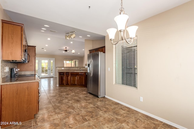 kitchen with decorative backsplash, appliances with stainless steel finishes, sink, ceiling fan with notable chandelier, and decorative light fixtures