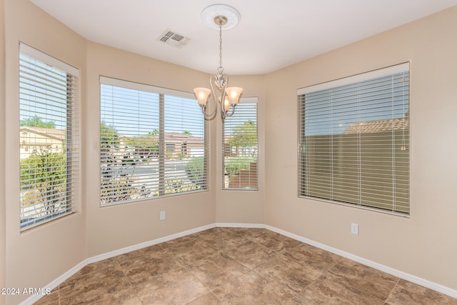 spare room featuring an inviting chandelier