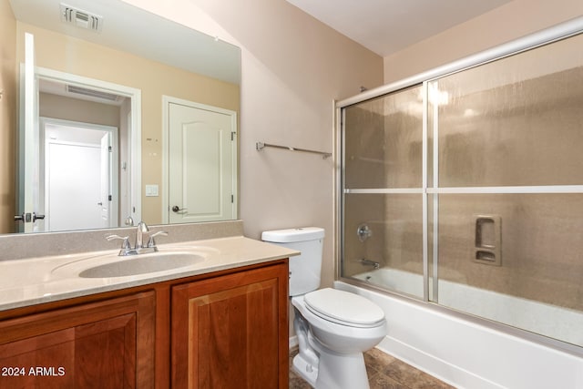 full bathroom with toilet, bath / shower combo with glass door, vanity, and tile patterned floors