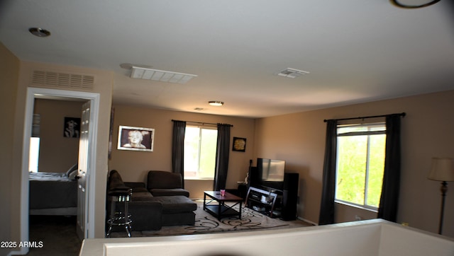 living area with baseboards and visible vents