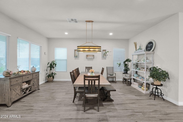 dining room featuring light wood-type flooring and a notable chandelier