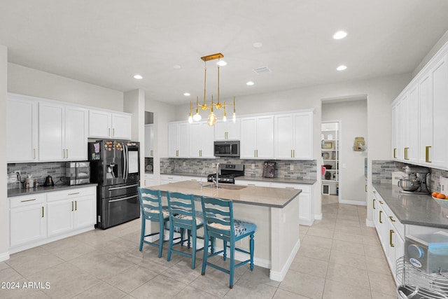 kitchen featuring decorative light fixtures, white cabinetry, and stainless steel appliances