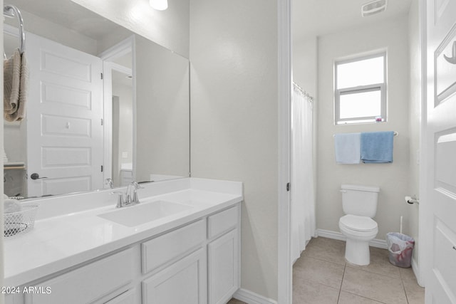 bathroom with tile patterned flooring, vanity, and toilet