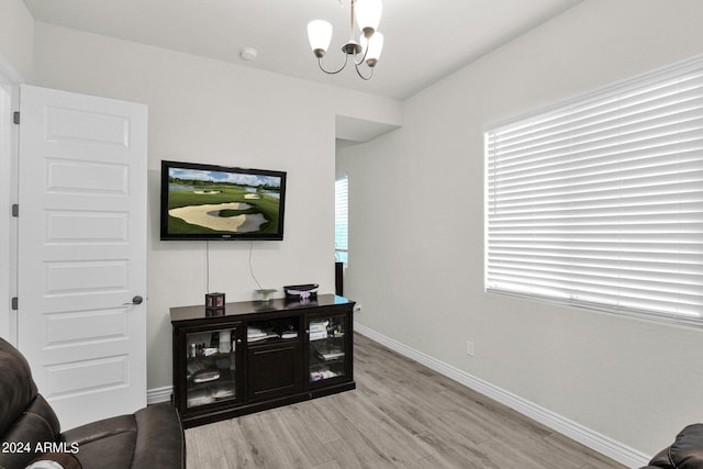 living room with a notable chandelier, plenty of natural light, and light hardwood / wood-style floors