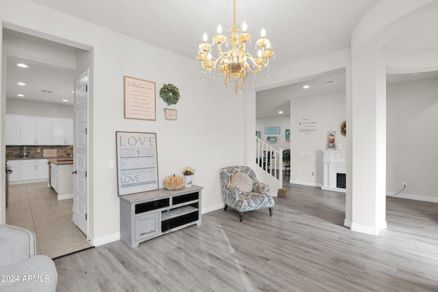 sitting room featuring a notable chandelier and light hardwood / wood-style flooring