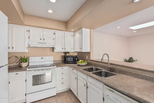 kitchen featuring a skylight, sink, light tile patterned flooring, white appliances, and white cabinets