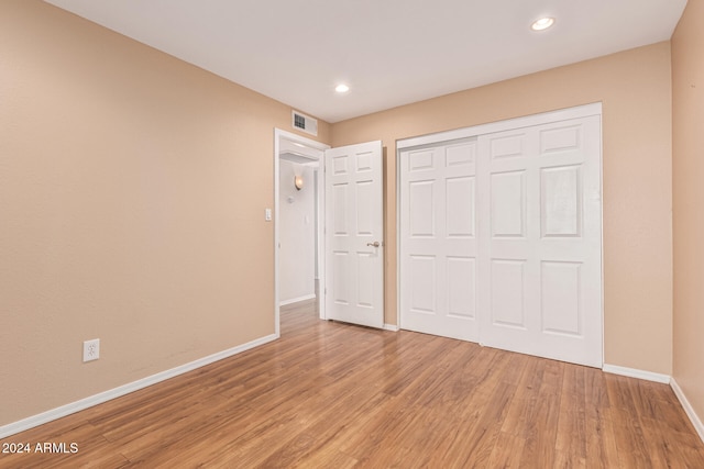 unfurnished bedroom with wood-type flooring and a closet