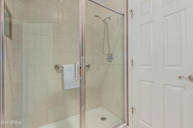 bathroom featuring a shower with door