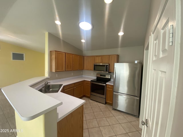10817 W Wilshire Dr, Avondale, AZ 85392 - kitchen featuring light countertops, vaulted ceiling, appliances with stainless steel finishes, a peninsula, and a sink