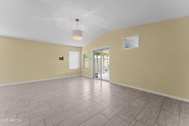10817 W Wilshire Dr, Avondale, AZ 85392 - empty room featuring vaulted ceiling, wood tiled floor, baseboards, and a chandelier