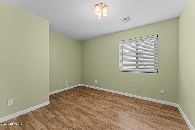 10817 W Wilshire Dr, Avondale, AZ 85392 - spare room featuring visible vents, baseboards, and wood finished floors